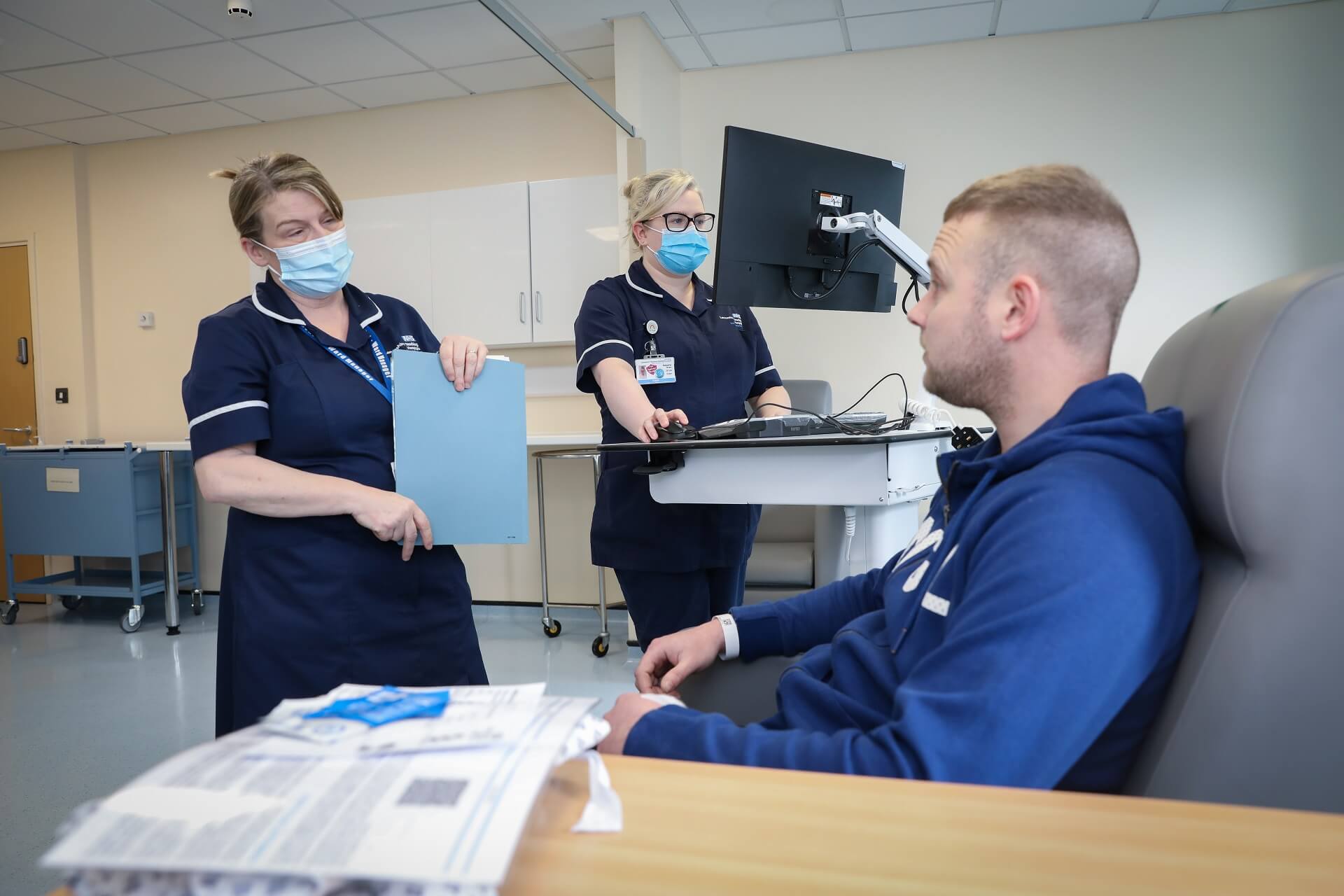 Staff member talking to patient in a well-lit medical setting