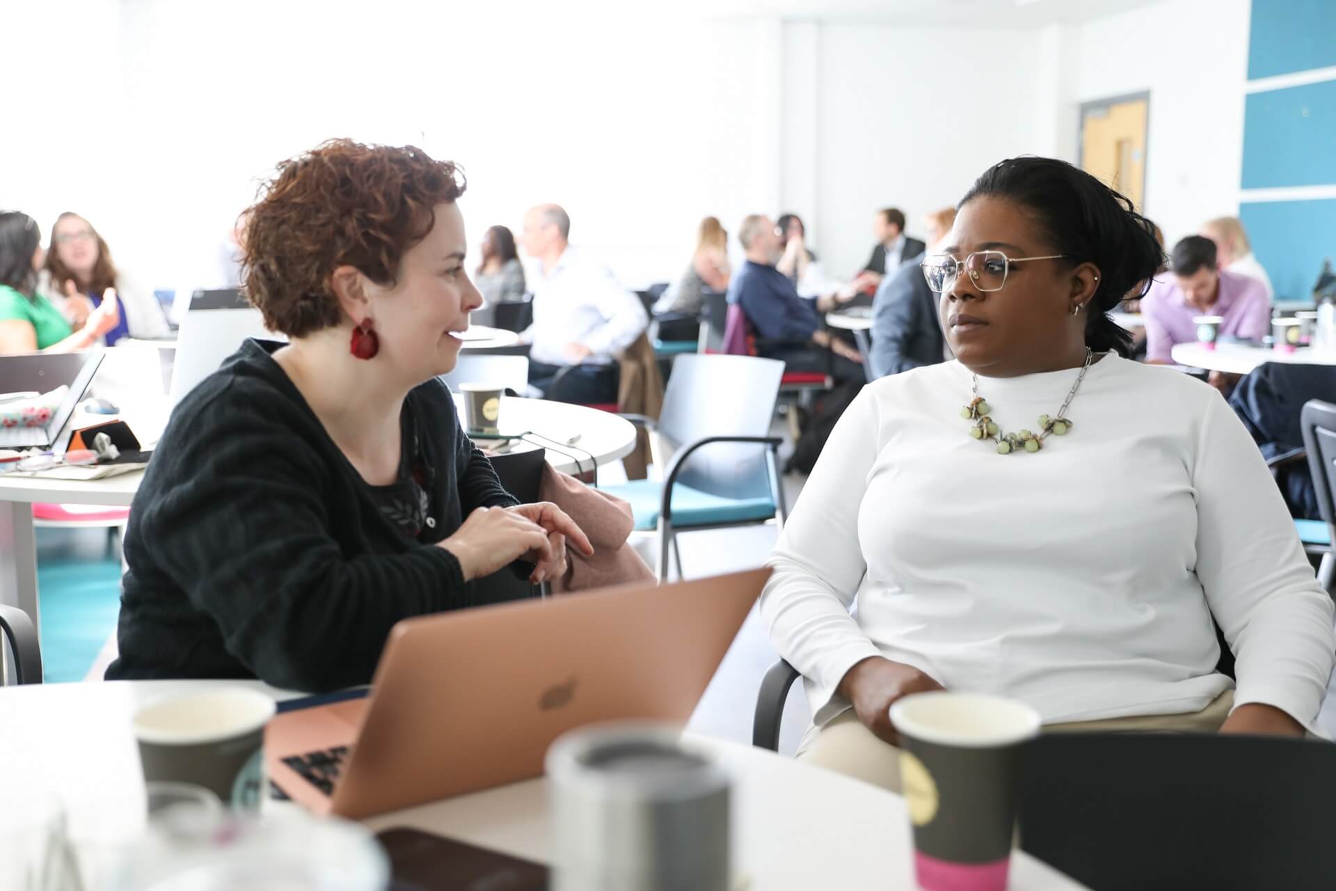 Two colleagues sitting around a desk, communicating