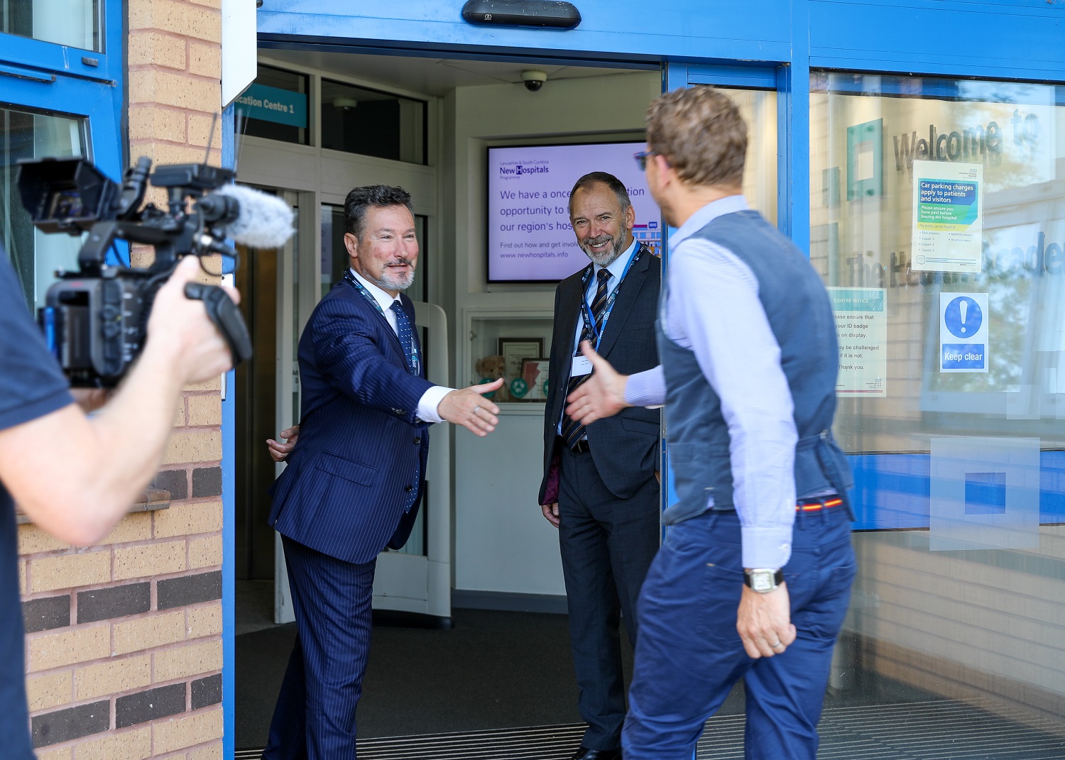 Photo of Kevin McGee welcoming Lord Nick Markham; Kevin is extending his arm to shake the Lord's arm.