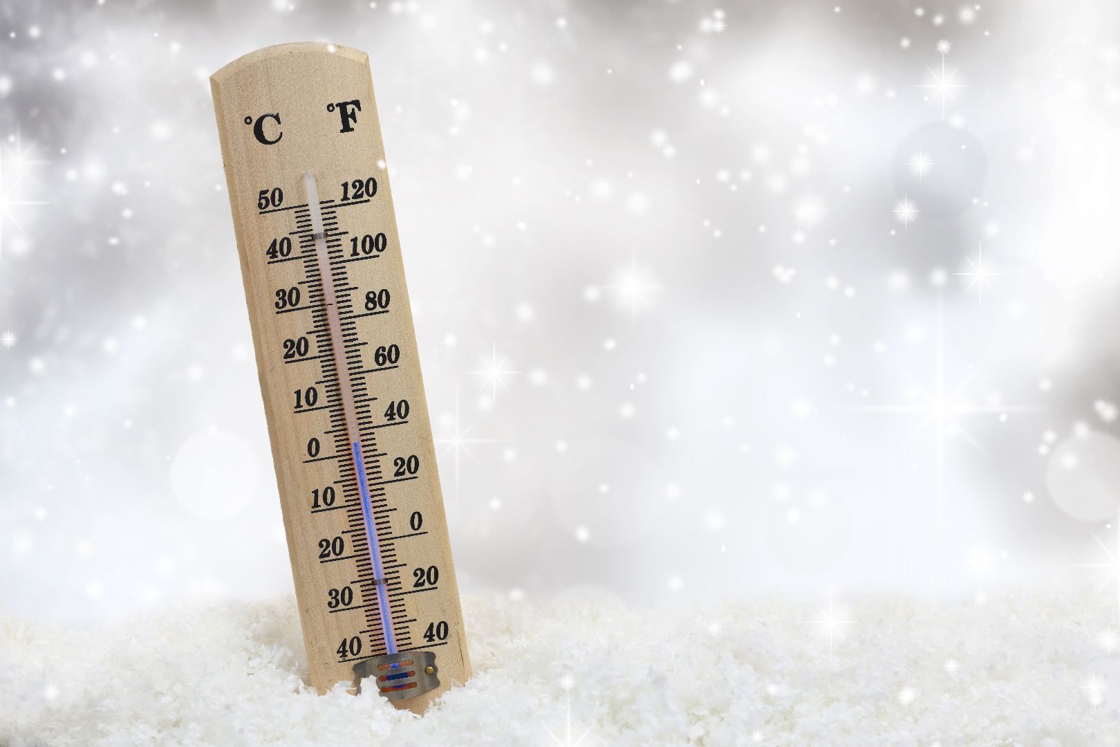 A stock photo depicting a thermometer in a heap of snow