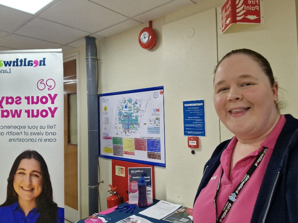 NHS Staff Member next to Healthwatch Lancashire poster