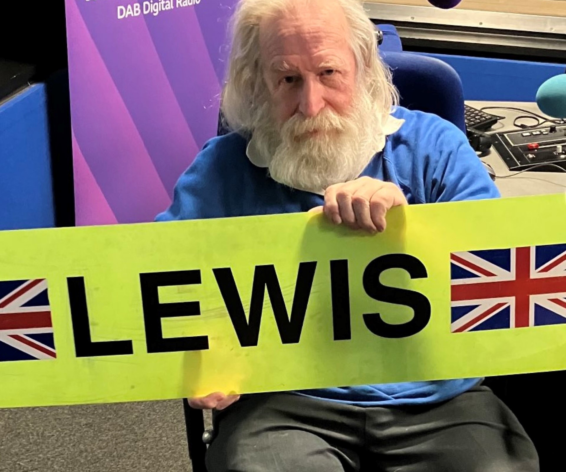 Photo of Steve Whalley holding a placard which reads Lewis