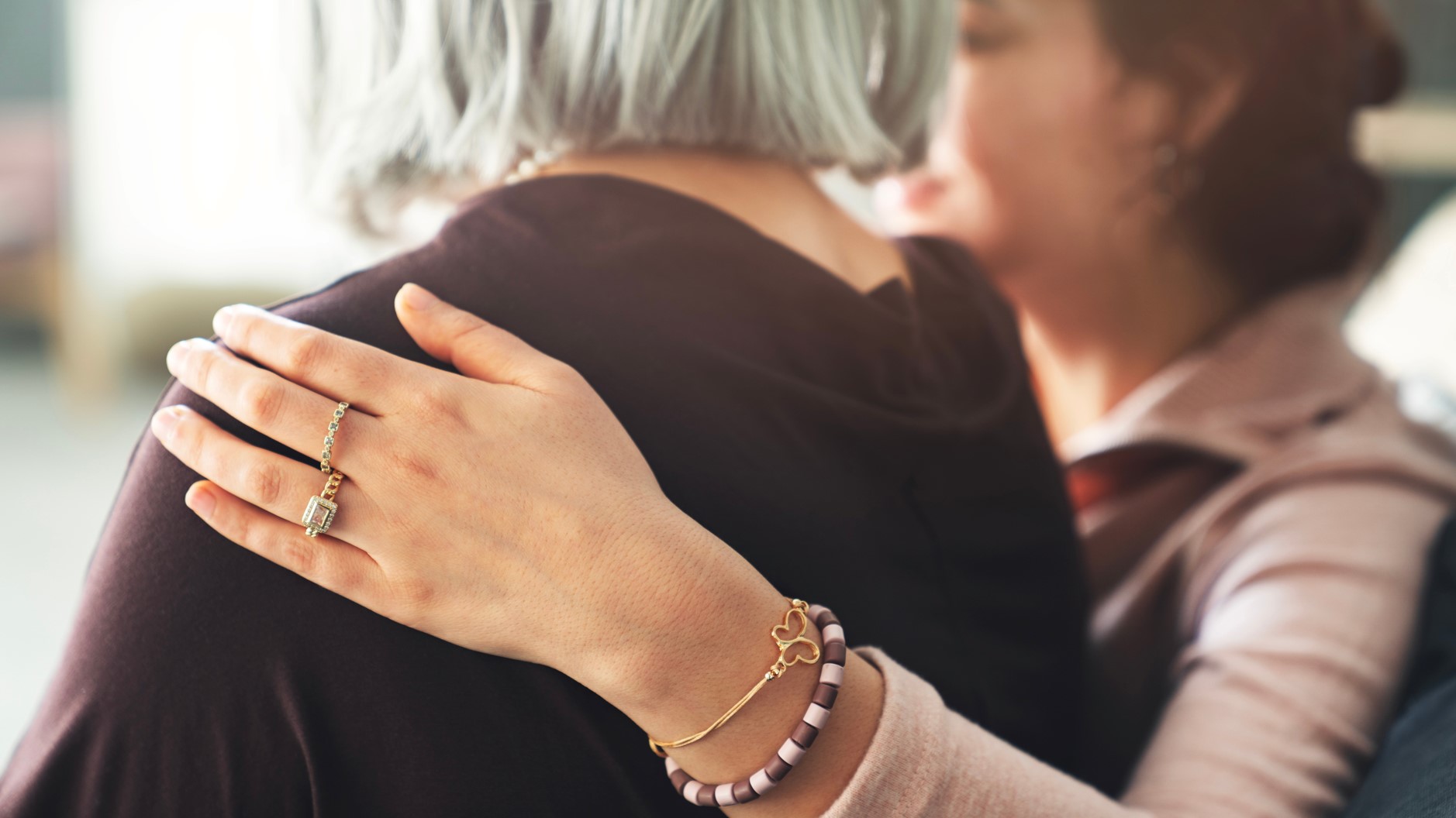 A photo of a younger woman having her hand on the shoulder of an older woman