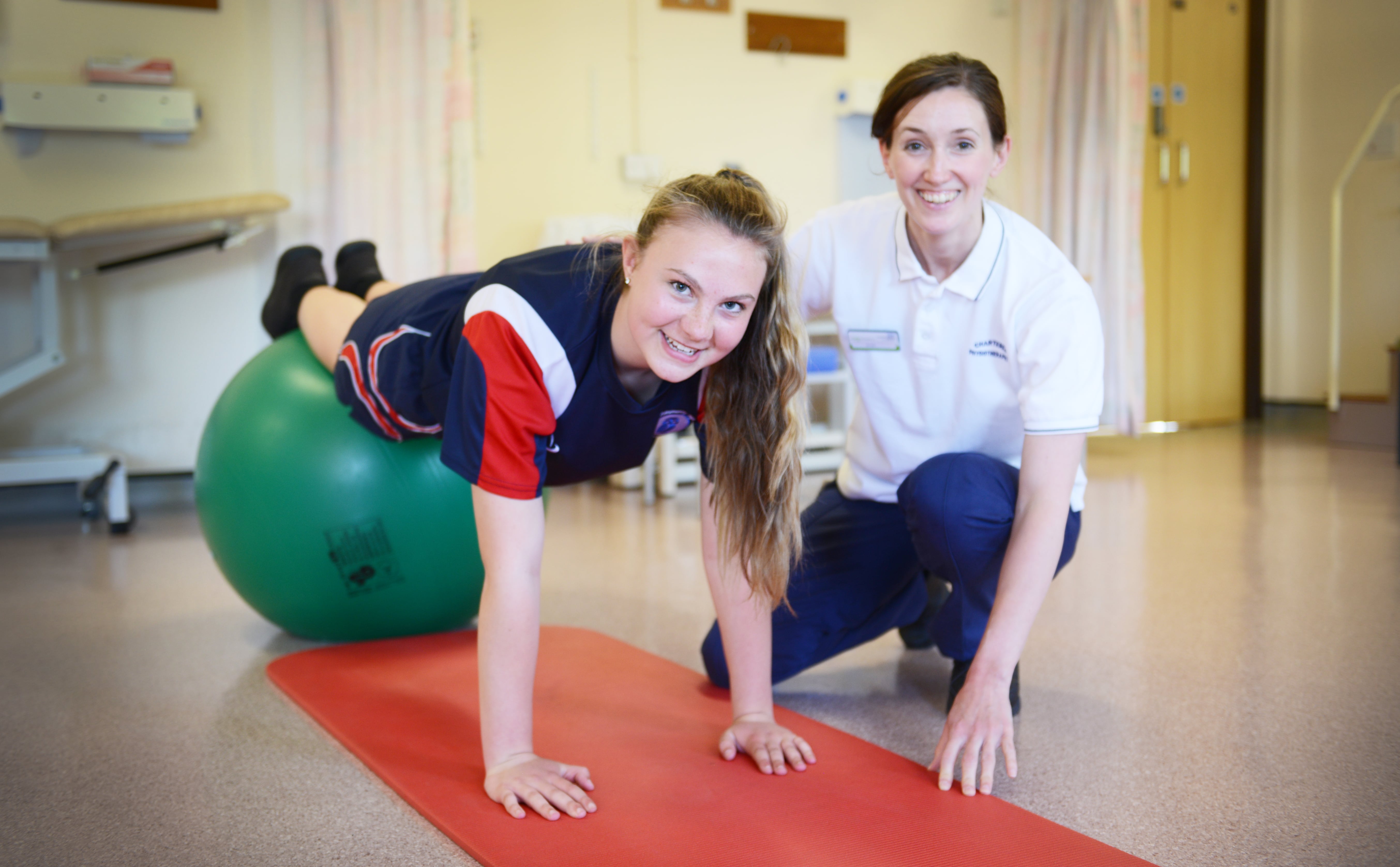 A young woman gets assistance from a physiotherapy worker